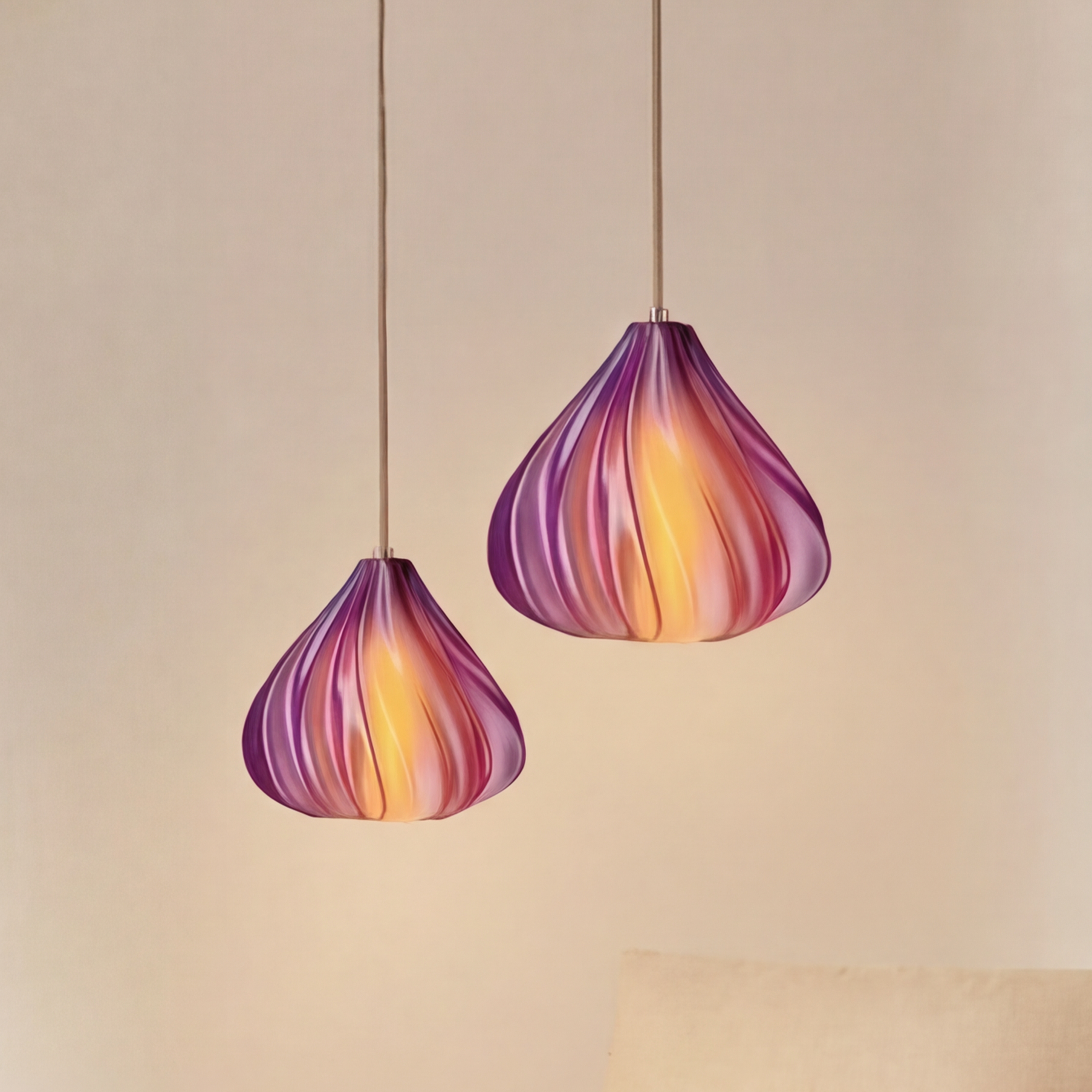 Two colorful pendant lights hanging above a modern living room setup with a beige sofa and wooden coffee table.