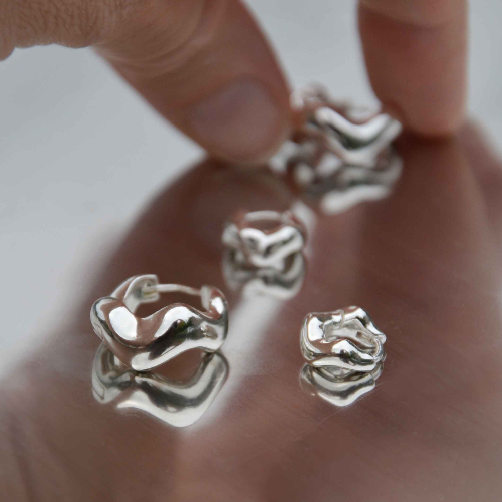 Silver ring on a hand with a plain background